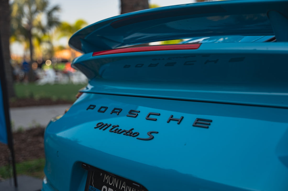 A blue porsche 911 turbo s sports its logo.