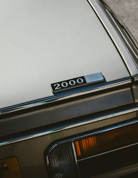 A silver car featuring a 2000 emblem.