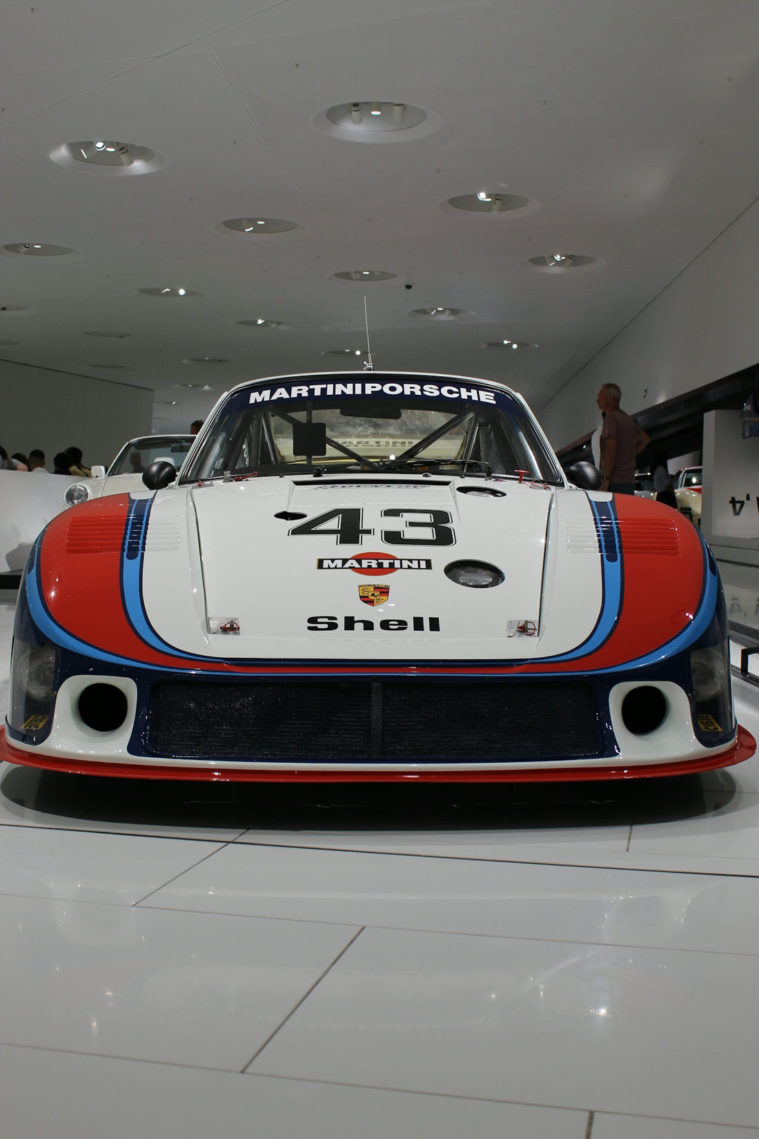 A martini porsche race car is on display.