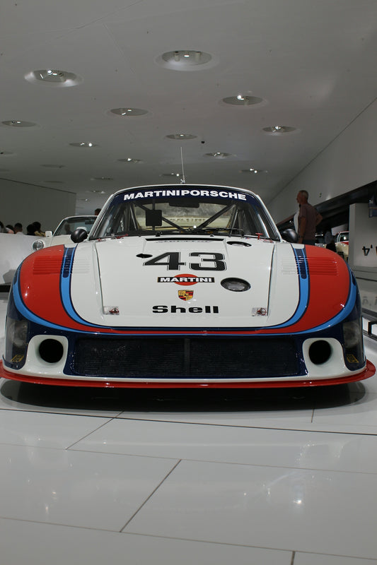 A martini porsche race car is on display.