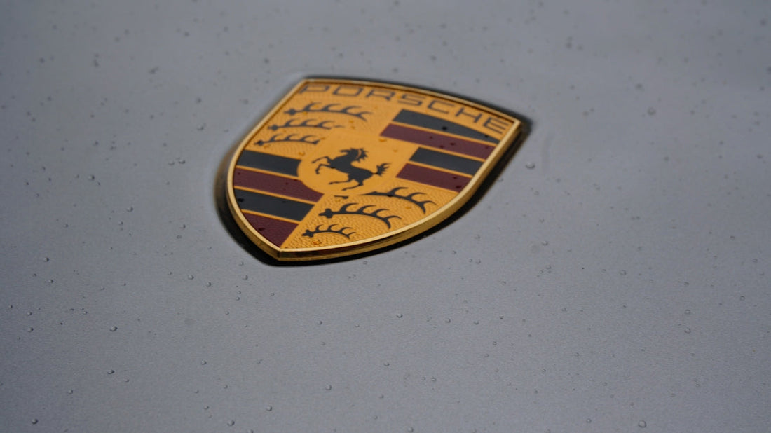 Porsche crest emblem with raindrops on grey supercar hood