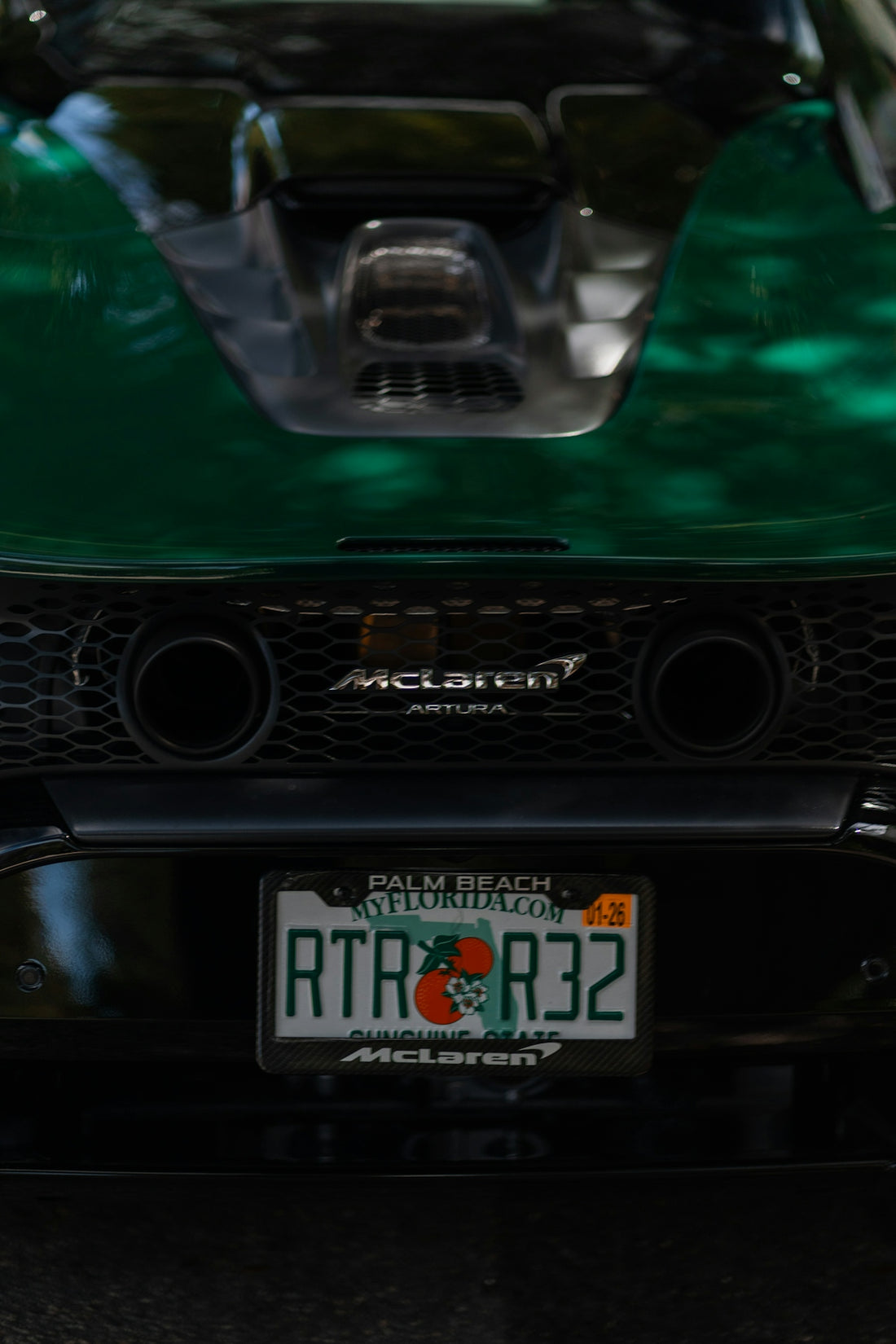 The rear end of a green mclaren artura.