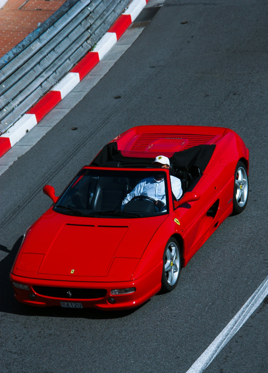 A red ferrari drives on a race track.