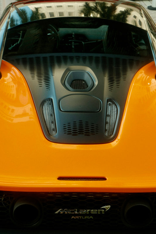 Rear view of an orange mclaren artura sports car