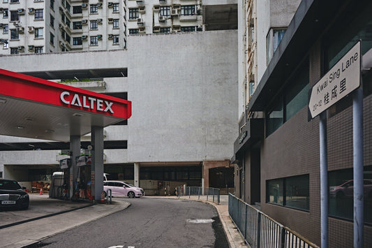 Caltex gas station at Kwai Sing Lane with high-rise buildings and parked cars in the city