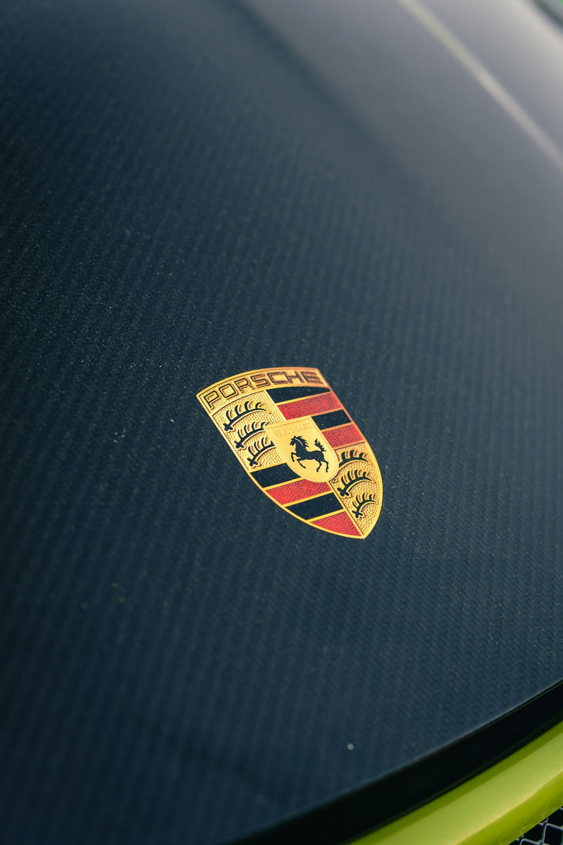 Porsche crest on a carbon fiber hood of an exotic sports car