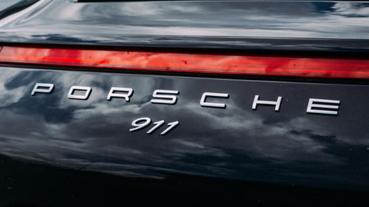 Porsche 911 emblem on a dark car.