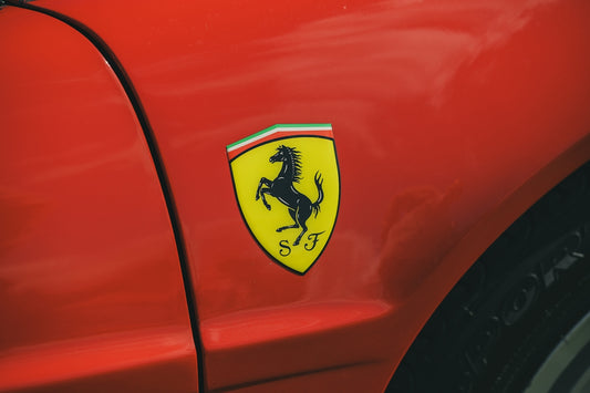 Close-up of a red ferrari car emblem.