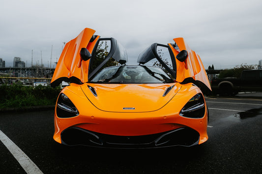Bright orange mclaren supercar with doors open