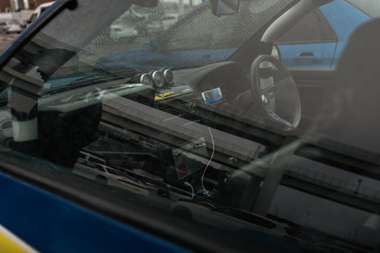 Racing car interior with sporty steering wheel, digital display, and performance gauges