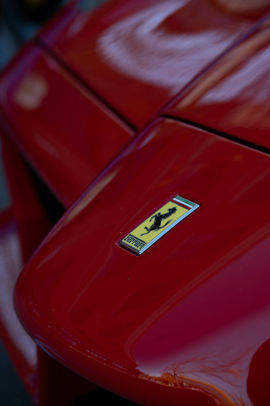 Close-up of a red ferrari car emblem.