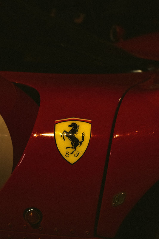 Close-up of a red ferrari car emblem.