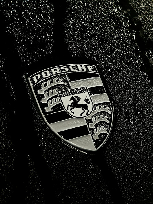 Porsche emblem on a textured dark surface