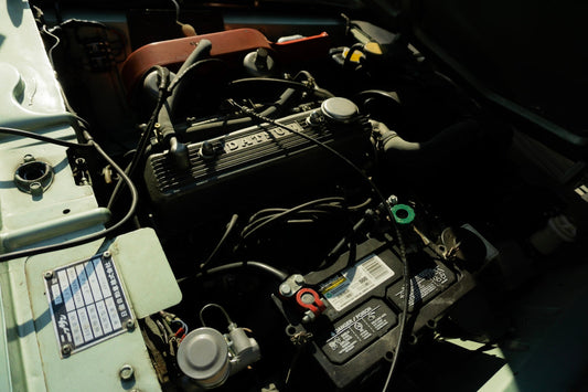 Close-up of classic Datsun car engine bay with battery and wiring visible