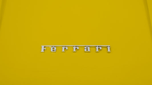Yellow car with a silver ferrari emblem