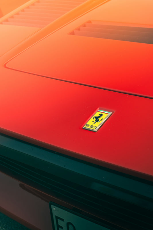 Close-up of a red ferrari car emblem.