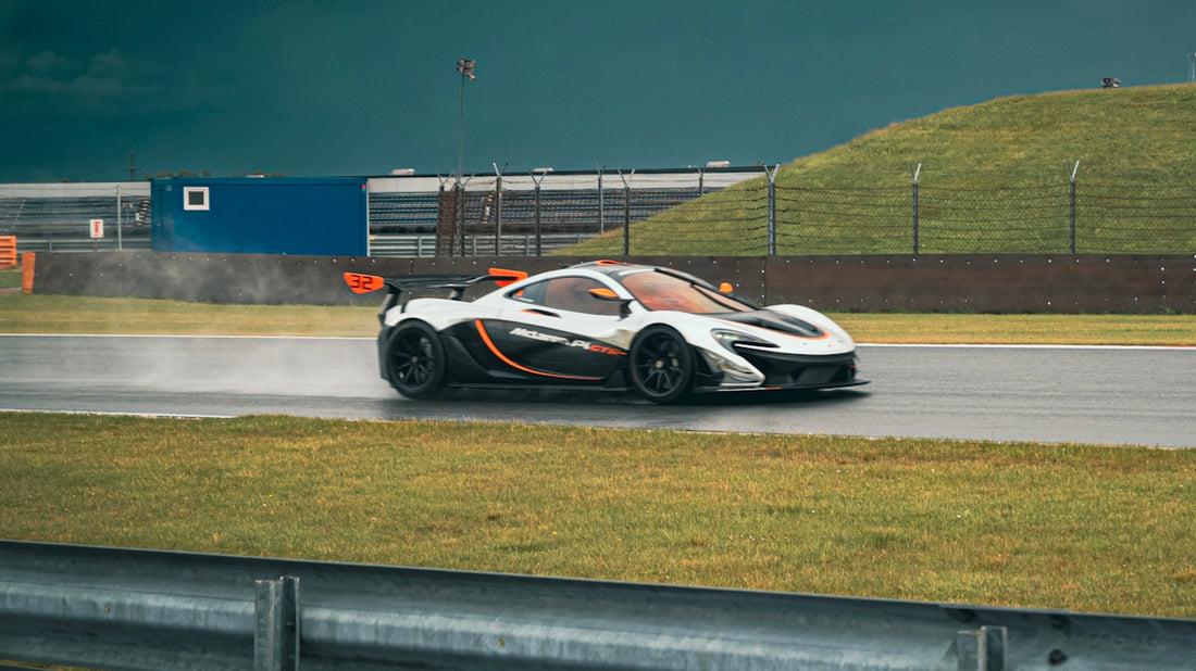 White mclaren p1 racing on a wet track.