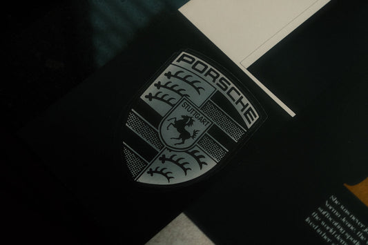 Close-up of a Porsche emblem, luxury sports car badge with Stuttgart text