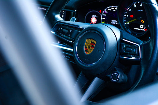 Modern porsche steering wheel and car dashboard.